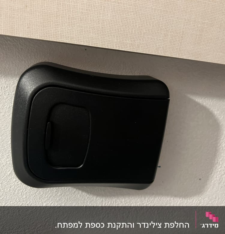 קופסת מפתחות שחורה מותקנת על קיר לבן
